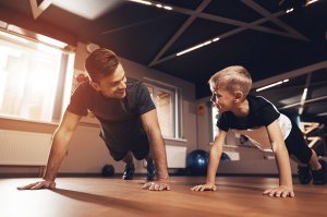 Father and son doing push ups in a home gym