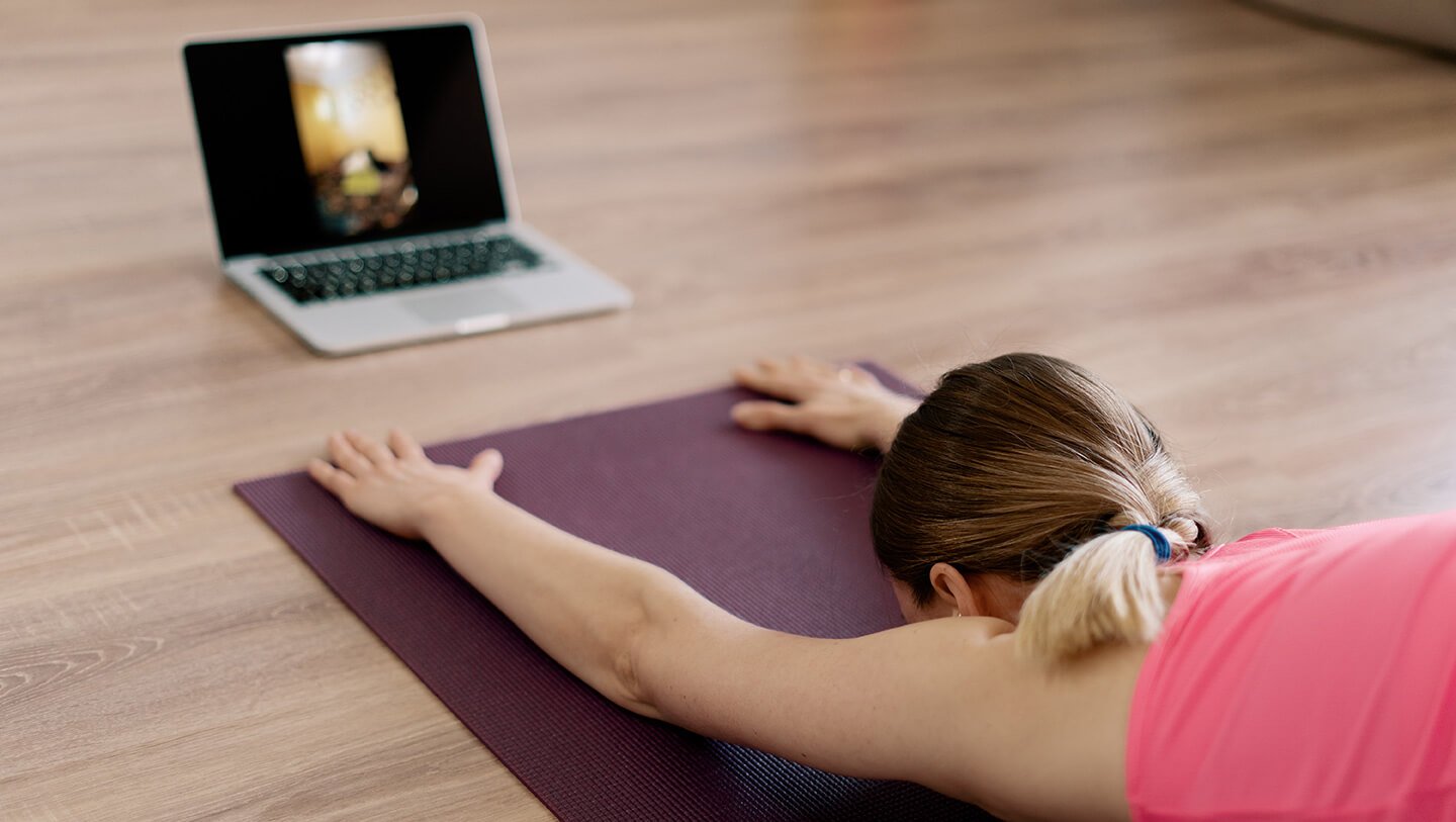 Woman practicing Yoga with laptop