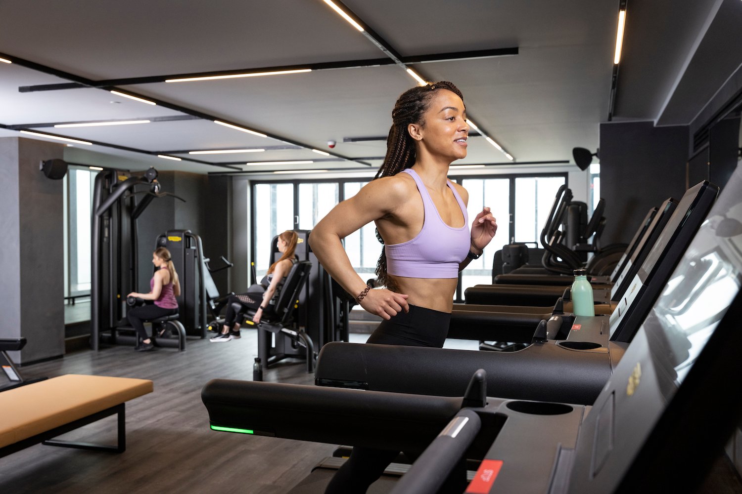 Woman running on a treadmill in a commercial gym